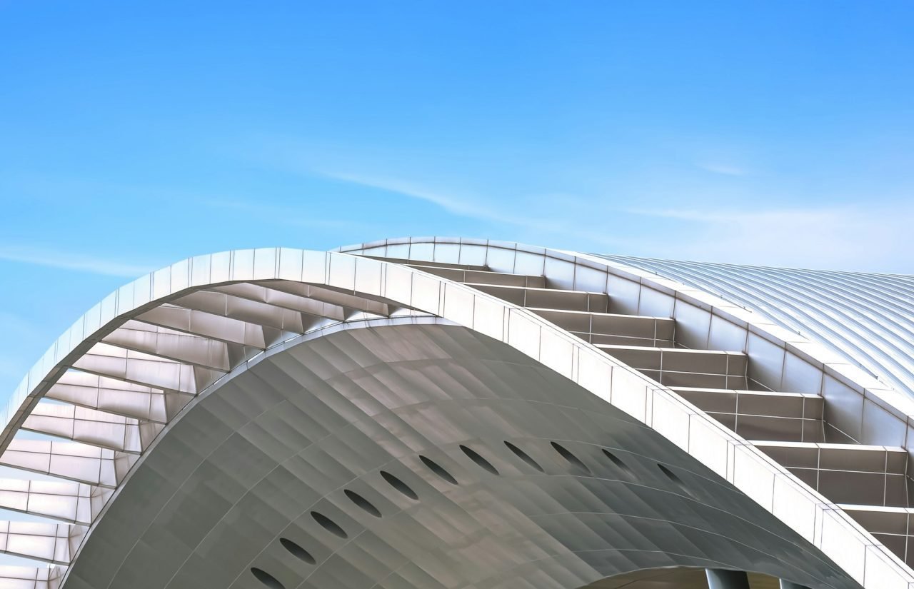 curve-metal-roof-of-modern-building-against-blue-sky-background.jpg